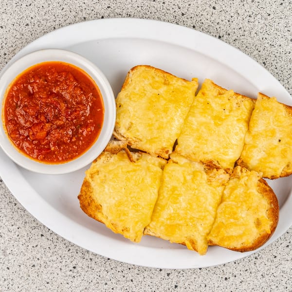 Cheesy garlic bread slices with a side of red marinara sauce on a white plate.