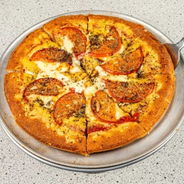 Santorini Pizza & Pasta's sliced pizza with tomatoes, cheese, and herbs on a metal pan.