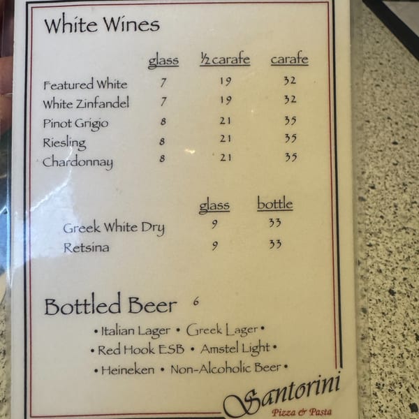 A white menu page from Santorini Pizza & Pasta displaying white wines and bottled beers.